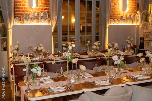 Close up view of wedding table setting with flowers and candles in a warm scene.