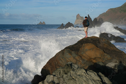 Obraz na plátně A man is watching the ocean from a huge cliff