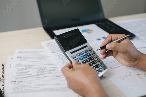 Canvas Print Close up of professional calculating income tax with calculator and documents on desk