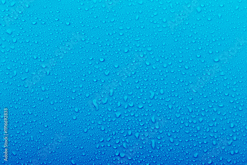 Water droplets on a blue background show textures and patterns created by moisture in the environment during a rainy day