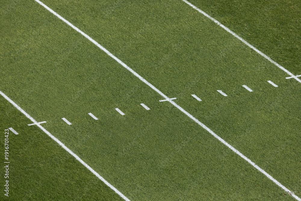 Fototapeta premium A view from above of an American Football grass field with field markings and yard lines. Generic football background image.