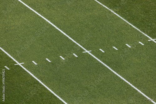 A view from above of an American Football grass field with field markings and yard lines. Generic football background image.