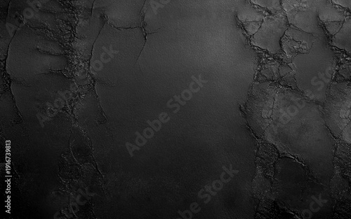 Dark grey black textured concrete wall background. A black background with no visible objects. The background is a solid black color and has a rough texture.