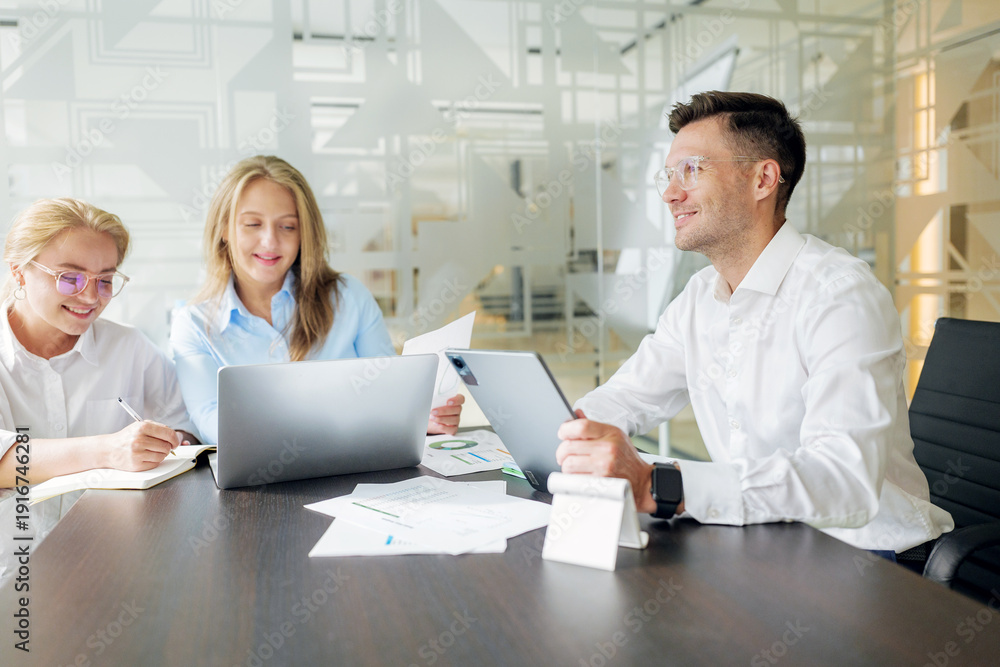 Obraz premium Team members work together in a meeting room with laptops and tablets during office hours