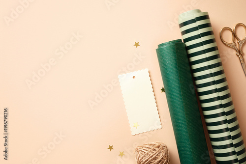Quadro su tela Flat lay of gift wrapping supplies with rolls of paper, scissors, twine and blank tag on beige background