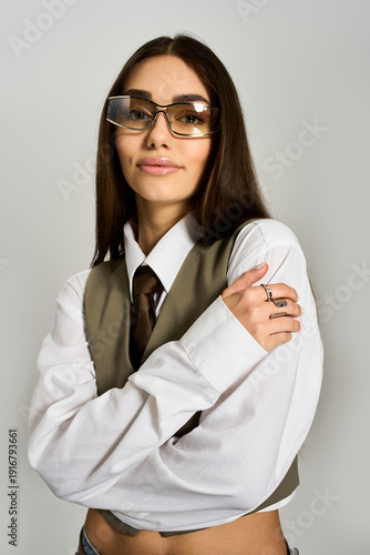 Confident young woman displaying elegance in a stylish outfit with glasses