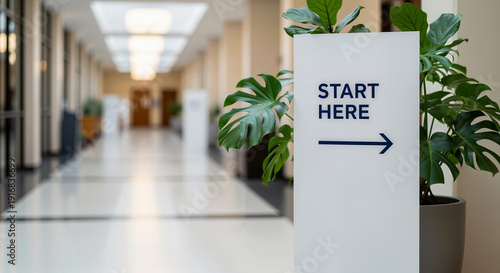 A sign pointing the way to Start Here at a Spring internship fair in a modern building.