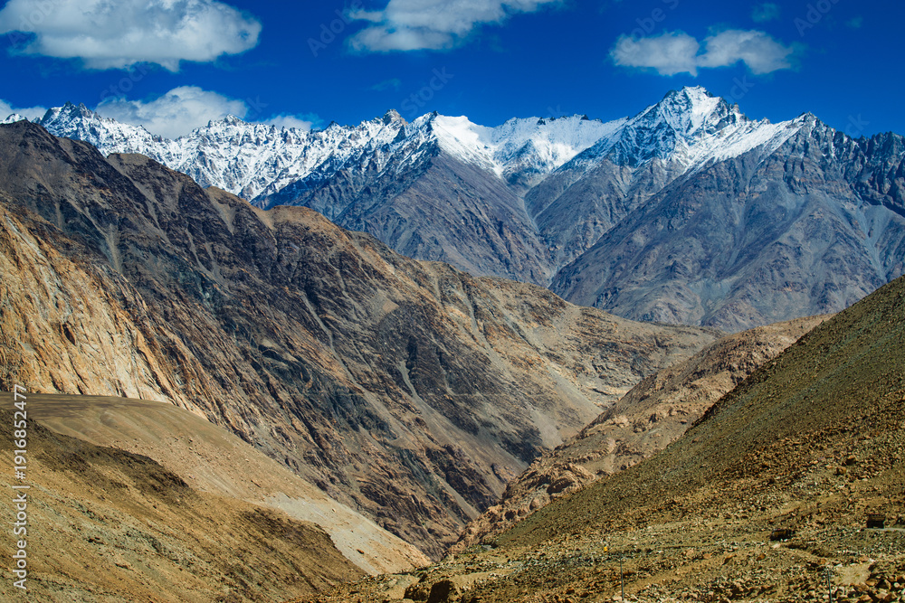 Fototapeta premium Snowy Himalayan peaks, blue sky at Chang La,southern pass, high mountain pass in Ladakh in the Greater Himalaya between Leh and the Shyok River valley. Leh to Pangong Lake road. Leh, Ladakh, India.