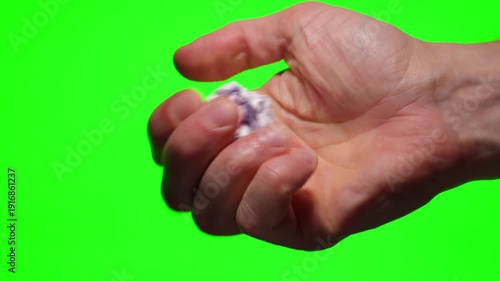 A close-up of a wrinkled paper ball on a green background.
Paper waste.
Used paper, crumpled by hand.
A damaged, wrinkled paper ball.
