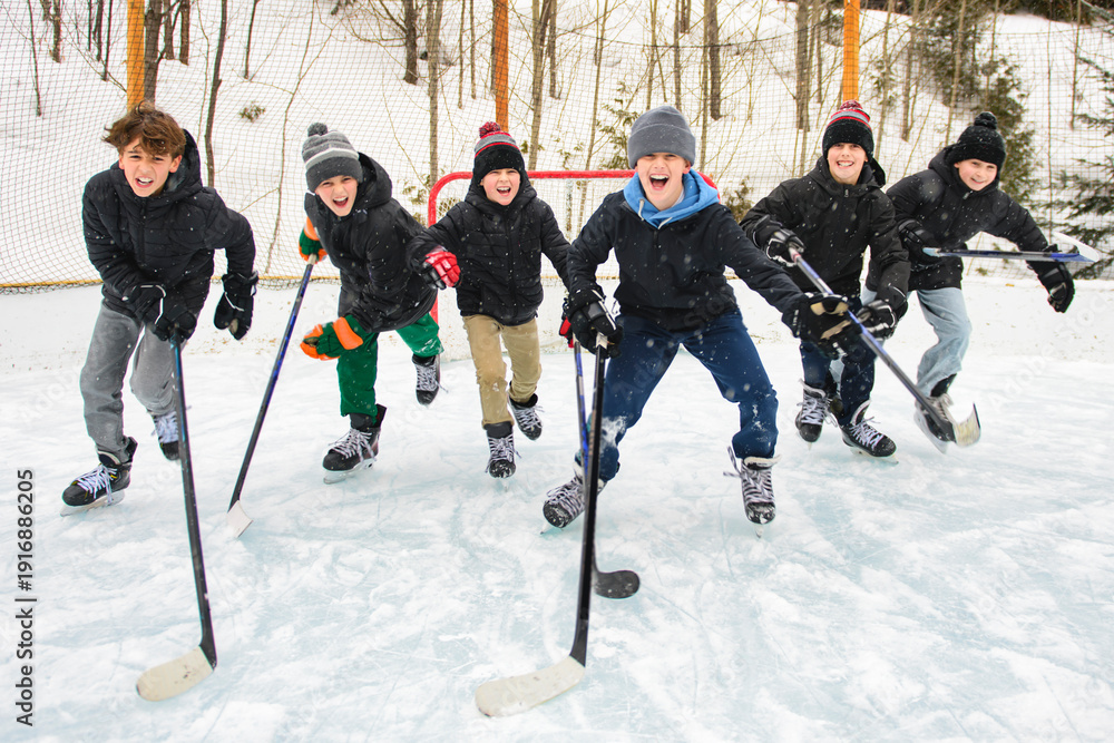 Obraz premium Ice hockey group of teen play hockey outside in winter. Sports winter games outdoors in winter.