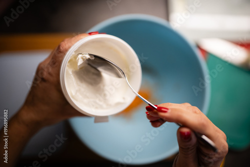 Bild auf Leinwand Woman's hands preparing food mixing yogurt