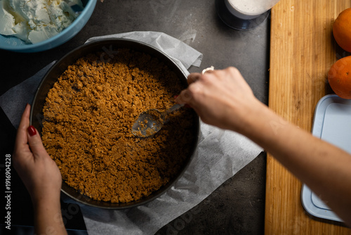 Foto Woman pressing cheesecake crust in springform pan