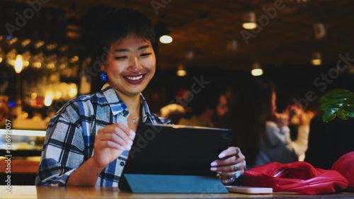 Young Asian designer drawing on tablet with stylus in cafe, creative freelancer working on digital project, female artist sketching on touch screen, authentic startup culture representation