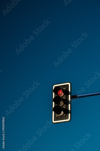 Red Traffic Light Against Clear Blue Sky