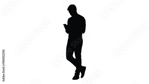 Silhouette of a man standing and looking at his mobile phone