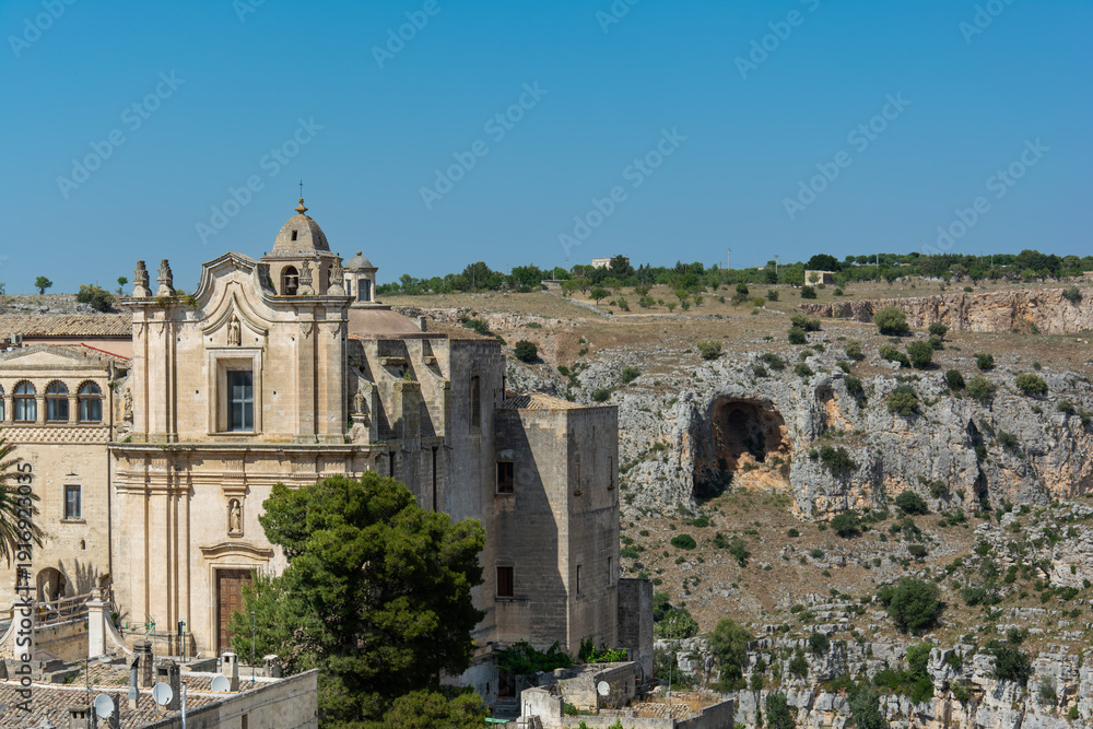 Fototapeta premium Historic stone church overlooking rocky canyon landscape under clear blue sky