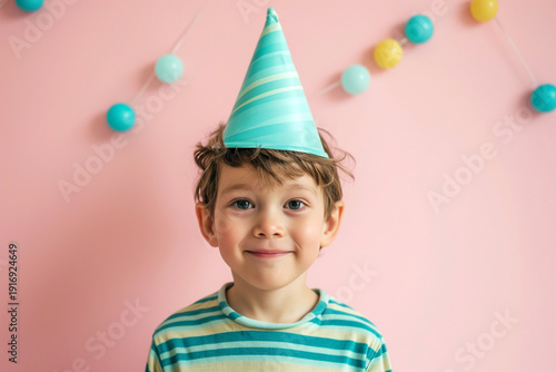 boy smiled with turquoise festive cone on head