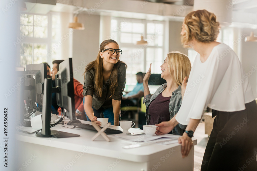 Fototapeta premium Coworkers laughing during coffee break in modern office