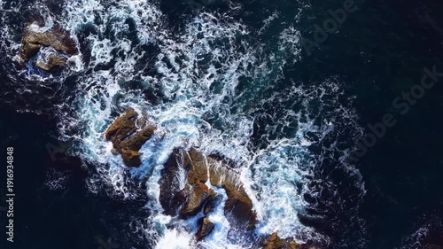 Wallpaper Mural Morning light glimmers on vibrant blue water as waves surge against rugged rocks, creating frothy white peaks. Nature's artistry is on full display, capturing a tranquil yet dynamic coastal scene. Torontodigital.ca