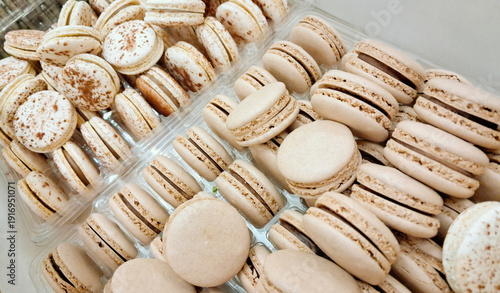 Beige macaron assortment in pastry trays for bakery display