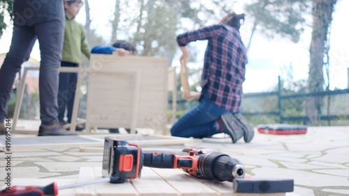 Принти на полотні Family building furniture outdoors, parents teaching child woodworking skills, h