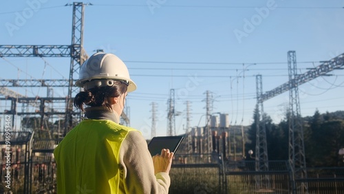 Принти на полотні Female engineer in safety gear checking infrastructure, using a digital tablet a