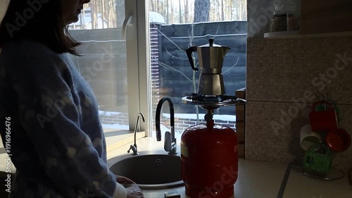 Young Ukrainian Woman Lighting Gas Stove to Make Coffee During Blackout