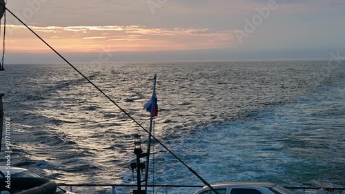 Enjoy the serene beauty of a cruise ship sailing across the endless ocean. Witness the vibrant sunset illuminating the waves while the ship glides smoothly.