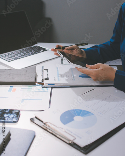 Businesswomen analyzing financial data, discussing investment strategy in office