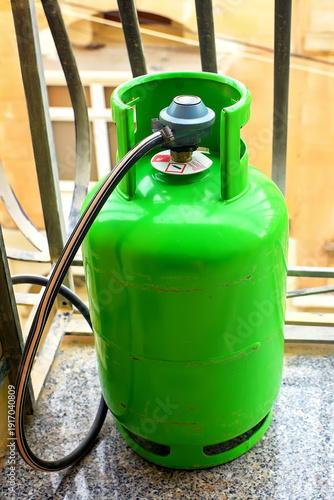 Obraz na płótnie View of a green LPG cylinder with a pressure regulator and hose on a balcony used for cooking in apartments in Mediterranean countries