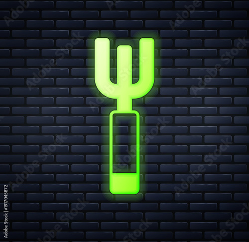Glowing neon Garden pitchfork icon isolated on brick wall background. Garden fork sign. Tool for horticulture, agriculture, farming. Vector
