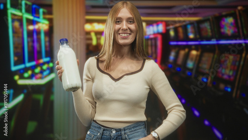 Canvas Print Woman holding a milk bottle in hand inside a casino building, smiling at camera; cheerful curiosity