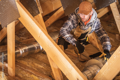Worker Installs Duct in Attic Space in Winter Time