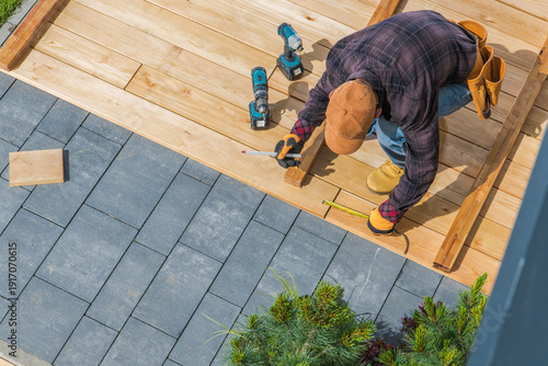 Man Working on Deck Installation in Backyard Area