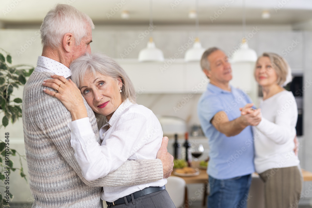 Fototapeta premium Couple dance at a house party in an apartment for elderly friends