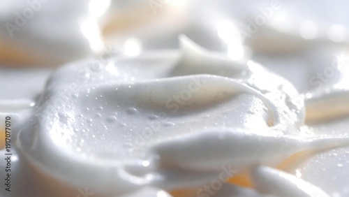 Close-up of luxurious, creamy moisturizer texture with light reflection.