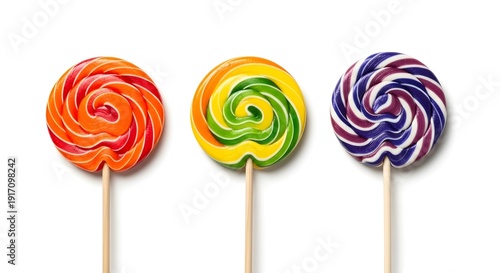 Three colorful swirl lollipops in orange, yellow-green, and purple-blue, isolated on a clean white background with a top-down view.