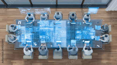 A group of people working on a futuristic digital interface at a conference table.