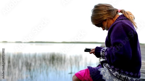 Wallpaper Mural Small girl in blue sweater reads an e-book Torontodigital.ca