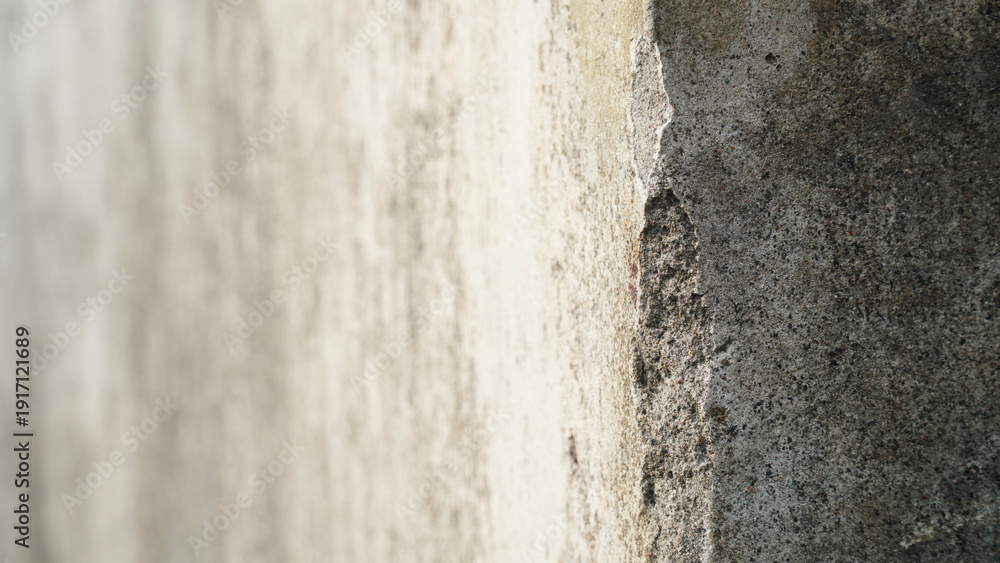 Fototapeta premium Detailed view of an old cement wall edge with chipped plaster and coarse surface