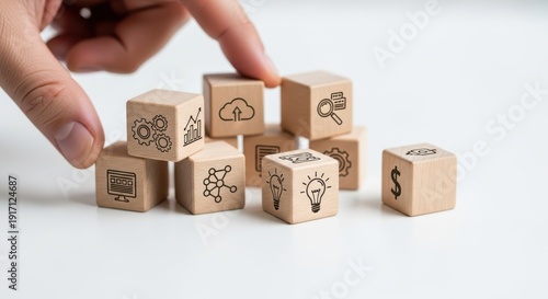 Wooden cubes representing digital transformation ideas arranged by hand with crisp macro detail and smooth white blur behind.
