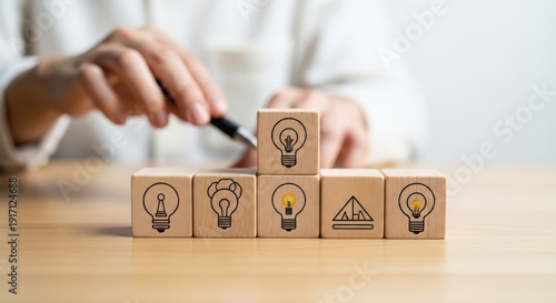 Wooden cubes representing digital transformation ideas arranged by hand with crisp macro detail and smooth white blur behind.