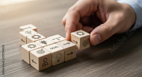 Strategic planning wooden cubes being organized by hand with professional macro focus and soft environmental background blur.
