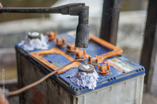 Slika na platnu a technician using a blowtorch to repair battery terminals on a lead-acid car battery in an automotive workshop