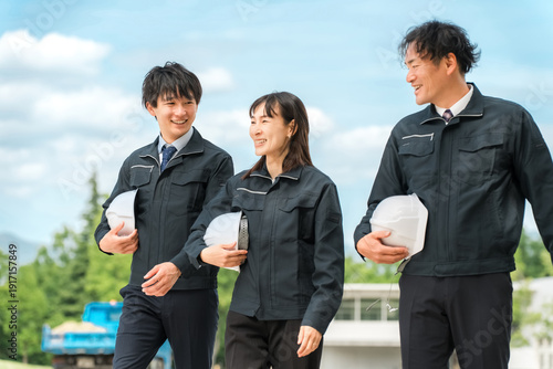Fototapeta 作業現場を歩く作業着姿の男女の作業員（建築業,運送業,土木業,ゼネコン）