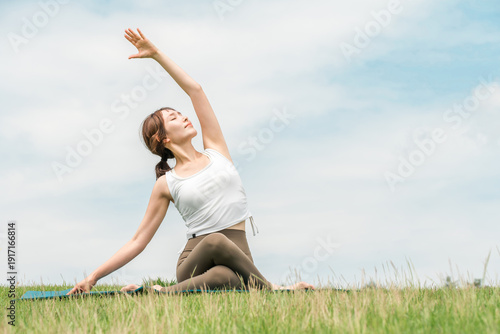 Foto A woman doing yoga, stretching, Pilates, and body care in the grassland (healthc