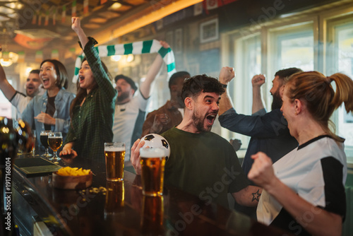 Fotografía Excited sports fans celebrating victory watching soccer match