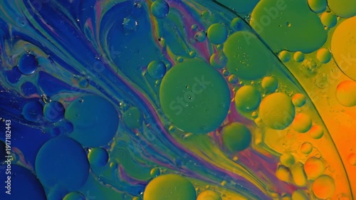 Vibrant multicolored abstract background with swirling liquids and bubbles.