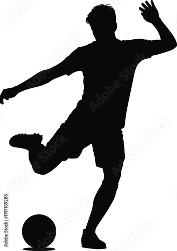 Silhouette of a soccer player kicking a ball