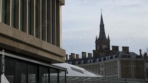 A scenic urban view of the historic Victorian Gothic station tower adjacent to the modern glass and timber landscraper architecture of the Google headquarters in the heart of London